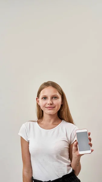 Lächelndes Europäisches Teenagermädchen Hält Und Zeigt Smartphone Und Schaut Die — Stockfoto