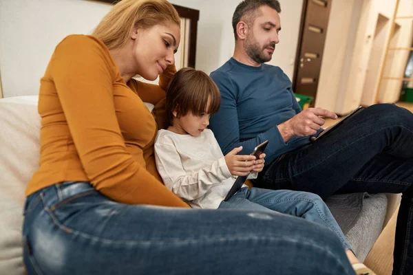 Jonge Kaukasische Familie Kijken Digitale Tabletten Bank Thuis Ouderschap Moeder — Stockfoto