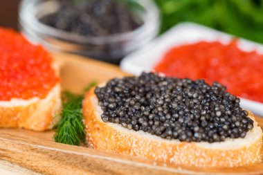 Siyah mersin balığı ve kırmızı somon havyarlı sandviçler.