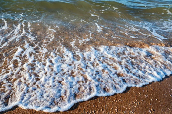 Närbild av havsvatten rinner ut på sandstranden. — Stockfoto