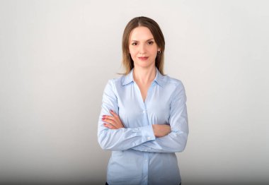 Kollarını kavuşturmuş genç ve güzel bir iş kadını.