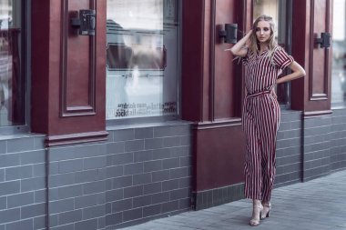 Uzun saçlı yoong modeli eski kafenin önünde poz veriyor.