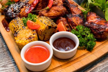 Ahşap masada sebzeli ızgara tavuk.