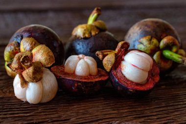 Ahşap masada taze soyulmuş mangosteen meyvesi. Yakın plan.