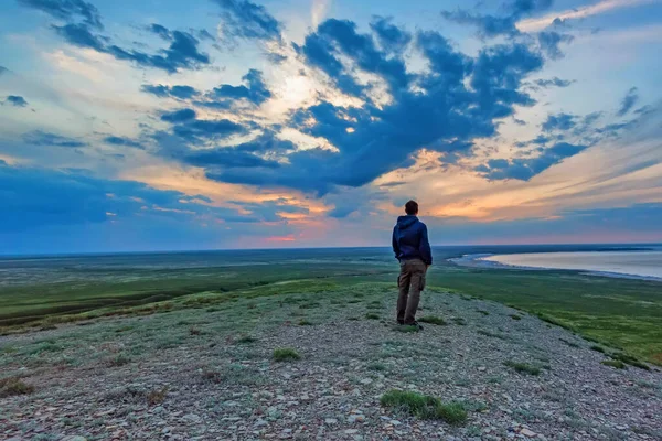 Zpět pohled mladý muž turista se dívá na moře a horizont — Stock fotografie