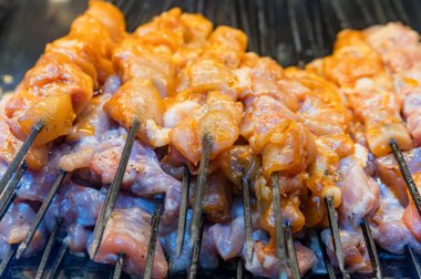 Şişte baharatlarla marine edilmiş çiğ domuz şişleri pişiriyorum.