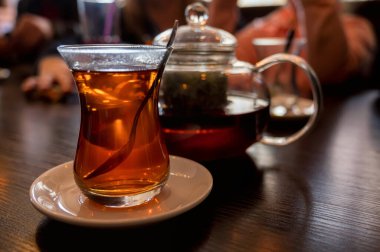 Modern cam çaydanlık ve bir fincan taze çay.