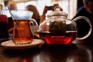 Modern cam çaydanlık ve bir fincan taze çay.