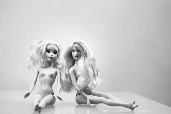 Beyaz masa üstünde iki barbie bebekler
