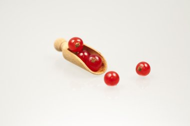 tahta kaşık içinde kırmızı kuş üzümü