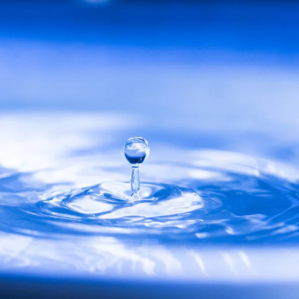 Round water drop falling into water — Stock Photo, Image