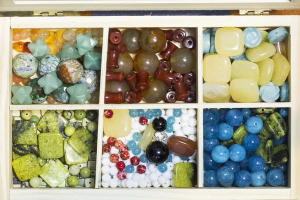 Wooden box with different gemstones — Stock Photo, Image