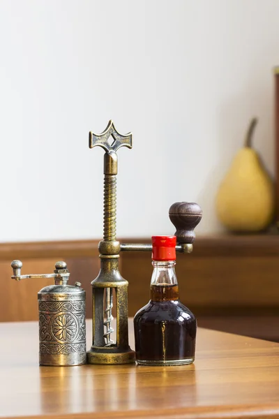 Composição ainda vida com moedor de pimenta metálica e pequena garrafa de vinagre aromático — Fotografia de Stock