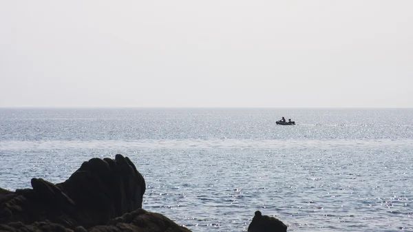 Hommes dans un bateau gonflable sur la mer — Photo