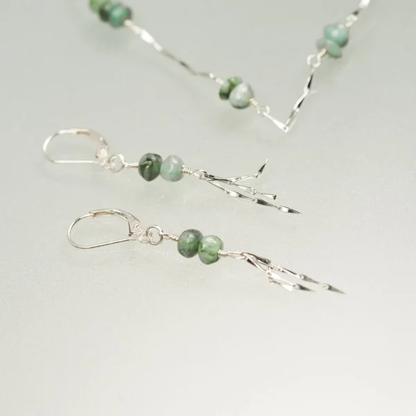 Silver earrings and necklace with emerald gemstones — Stock Photo, Image