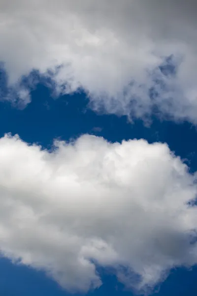 Nubes esponjosas, blancas y grises y cielo azul —  Fotos de Stock