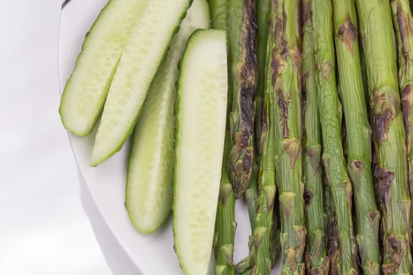 Fresh cucumbers and grilled asparagus — Stock Photo, Image