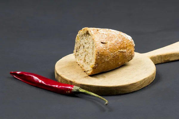 Placa de corte de cozinha, pão e pimenta vermelha — Fotografia de Stock