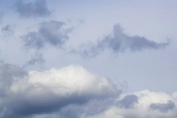 Nubes esponjosas, blancas y grises y cielo azul —  Fotos de Stock