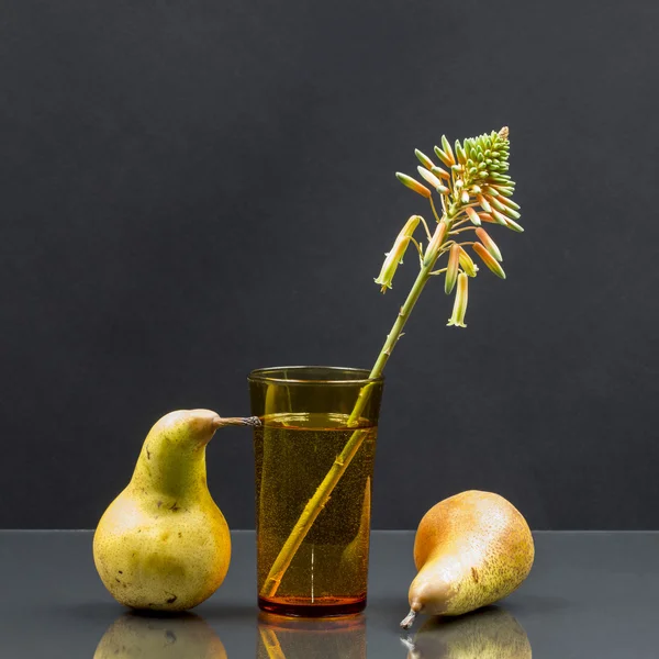 Kwiat aloesu w szklance wody i gruszki — Zdjęcie stockowe