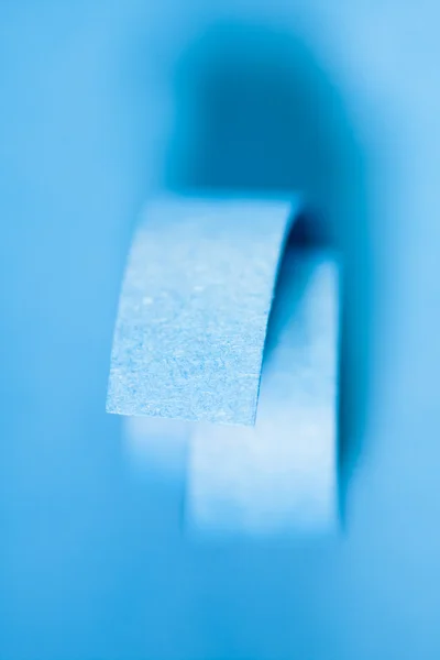 Espirales de papel azul sobre fondo de papel —  Fotos de Stock
