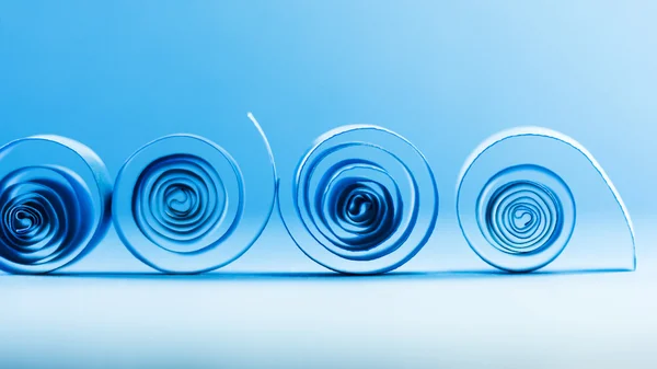 Blue paper spirals on paper background — Stock Photo, Image