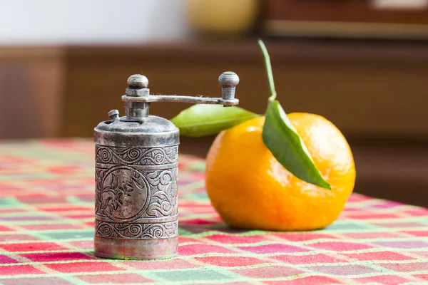 Pepper grinder and tangerine — Stock Photo, Image
