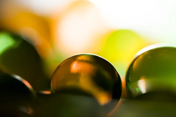Composição abstrata com belas bolas de geleia redondas transparentes em uma folha de alumínio com reflexos e fundo escuro — Fotografia de Stock