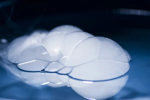 Abstract shot with big soap bubbles on a water surface with smoke inside — Stock Photo, Image