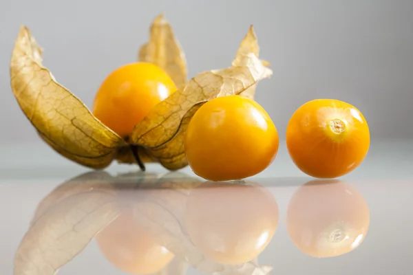 Closeup physalis peruviana φρούτων με ανοιχτό γκρι φόντο και αντανακλάσεις — Φωτογραφία Αρχείου