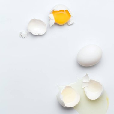 Beyaz arka planda kırılmış beyaz yumurtalar.
