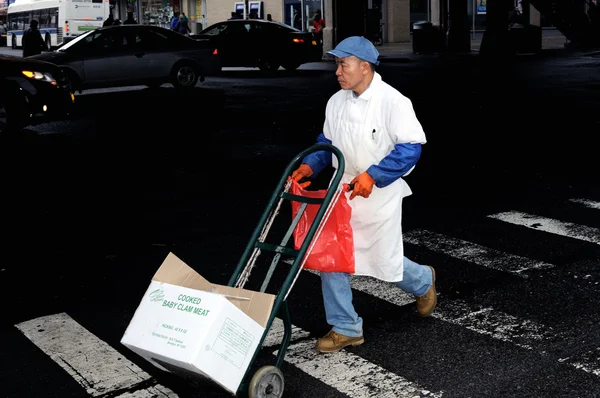 Den kinesiska arbetaren transporterar en box med produkter. — Stockfoto