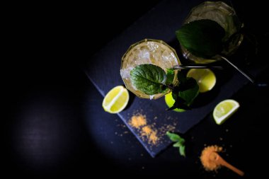 Siyah arka planda naneli, limonlu ve buzlu iki renkli yaz içeceği. düz yat