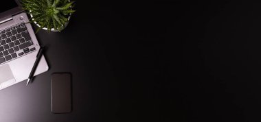 Bilgisayarı ve tedarikçisi olan siyah ofis masasının üst görünümü