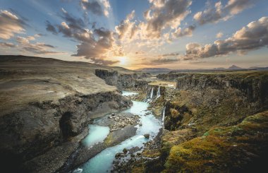 İzlanda 'nın turkuaz nehri ve günbatımı ile dağlık bölgelerdeki inanılmaz Sigoldugljufur kanyonunun manzarası. Arka planda volkanik manzara. Popüler turistik cazibe.