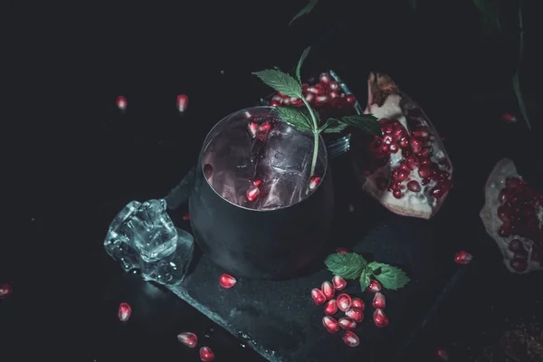 赤い冷たいウォッカとザクロ ジュース アイス キューブ ローズマリー バーのカウンターの背景 ツール 青黒バーとカクテルをコピー領域の選択と集中 — ストック写真