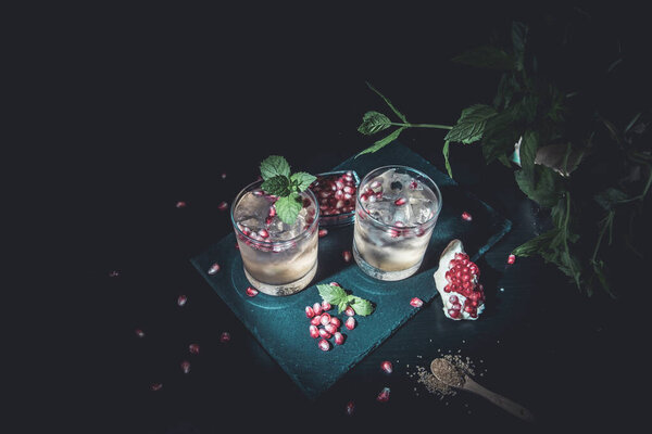 Two summer drinks with pomgranate, mint and some sugar. flat lay and moody look