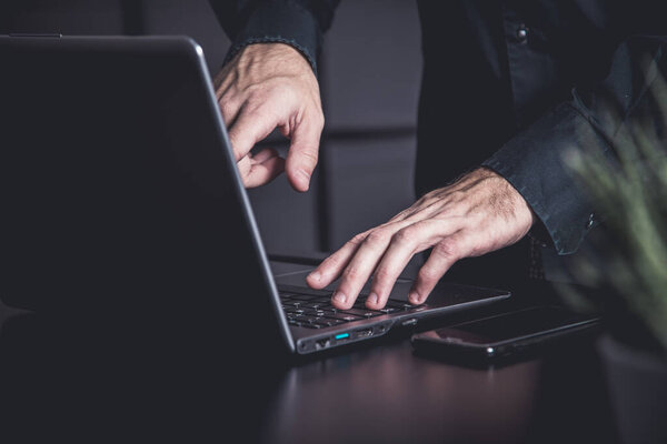 Moody office with a businessman with samrtphone and notebook