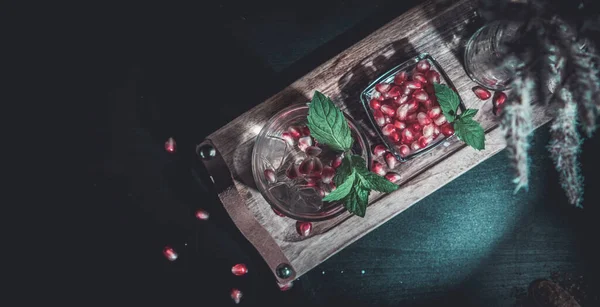 Soğuk votka ve nar suyu, buz küpleri ve biberiye, araçlar, mavi siyah counter arka plan, bar bar kokteyl kırmızı kopyalama alanı, seçici odak