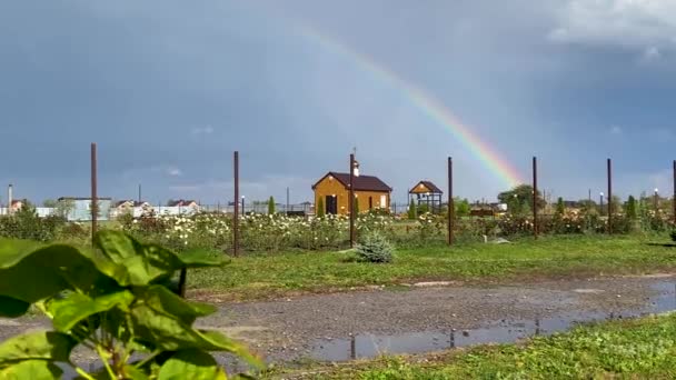 Colorful rainbow over small Russian Orthodox church as a positive symbol of change, faith and divine miracles. natural phenomenon after the rain. Blessing of temple. — Stock Video
