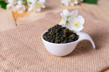 Kasede yeşil çay ve bej arka planda mis kokulu yasemin çiçekleri..