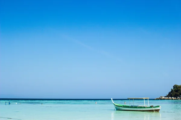Hermosa pequeña embarcación de pesca de madera situada en el mar azul y el cielo — Foto de Stock