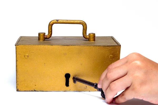 Hand holding key and treasure trunk — Stock Photo, Image