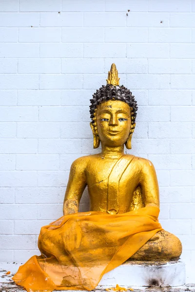 Zlatý buddha na bílém pozadí cihlový blok — Stock fotografie