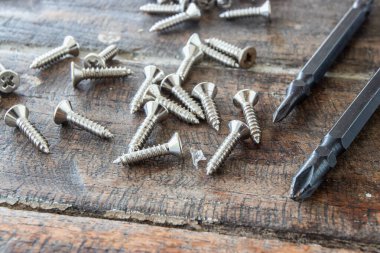 Tornavidaların başı ve tahta arka plandaki vidalar..