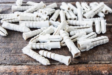 Ahşap arka planda plastik duvar tıkaçları.