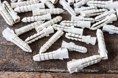 Ahşap arka planda plastik duvar tıkaçları.