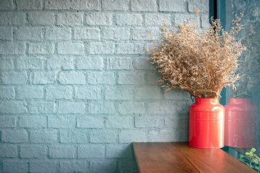 Ahşap masadaki kırmızı kaplarda güzel bir ağaç ve arka planda beton duvar..