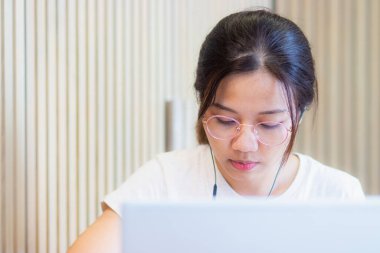 Virüs salgını sırasında evden çalışma. Dizüstü bilgisayarla çalışan çekici genç bir kadın ve ekiple video konferansı.