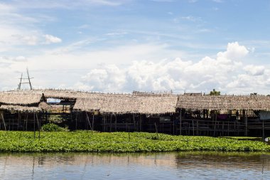 A wooden hut on white cloud and blue sky at Saphanburi Arch bridge local Market, Thailand.